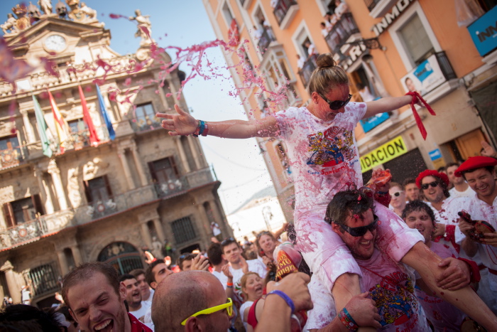 Neska bat ardo eta sangriaz blai, Sanferminetako jaiei hasiera emango dion txupin jaurtitzearen zain, jendez lepo dagoen udaletxeko plazan. Iruñea (Euskal Herria) 2013ko Uztailak 6. Urtero, zoko guztietatik etorritako milaka lagunek Iruñeako kaleak hartzen dituzte, mundu mailan ezagun den astebeteko jai giroan murgiltzeko. (Gari Garaialde/Bostok Photo)